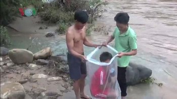 Salah satunya dengan mempekerjakan seorang pria untuk membantu anak-anak mengantar mereka sampai ke sekolah dengan plastik. (Foto: VOV)