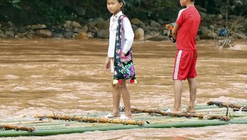 Pasalnya ketika musim hujan tiba mereka harus menggunakan kantong plastik sebagai alat transportasi seadanya untuk menyberang. (Foto: VOV)