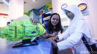 Seorang petugas tengah menjelaskan kecanggihan robot ikan yang dapat hidup di air layaknya ikan sungguhan. (Rifkianto Nugroho/detikcom)