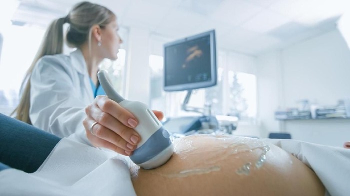 usg perut In the Hospital, Close-up Shot of the Doctor does Ultrasound / Sonogram Procedure to a Pregnant Woman. Obstetrician Moving Transducer on the Belly of the Future Mother.