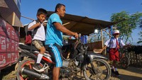 Penampakan dua orang siswa bersiap menuju ke sekolah dengan diantar orang tua di Kamp Pengungsian Jono Oge, Kabupaten Sigi, Sulawesi Tengah, Senin (15/7/2019). Antara Foto/Mohamad Hamzah.