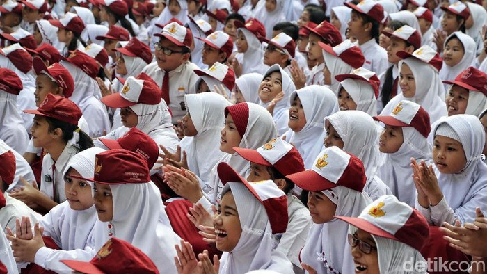 Ratusan siswa SD mengikuti upacara di Hari pertama sekolah di SDN 01 Rawa Badak Utara, Jakarta Utara. Mereka memakai seragam Merah Putih.