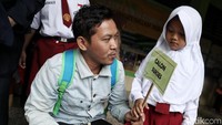 Beberapa orang tua terus memberikan semangat kepada anaknya di hari pertama sekolah.