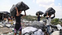 Para pemulung ini mulai mengumpulkan barang-barang untuk dipindahkan.