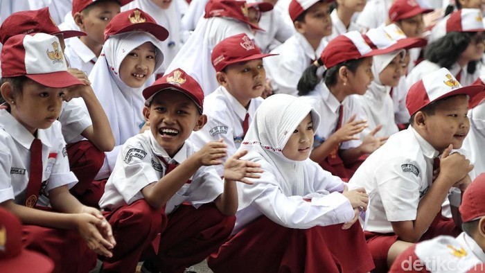 Ratusan siswa SD mengikuti upacara di Hari pertama sekolah di SDN 01 Rawa Badak Utara, Jakarta Utara. Mereka memakai seragam Merah Putih.