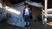 Seorang siswa bersiap menuju sekolah pada hari pertama masuk sekolah di Kamp Pengungsian Jono Oge, Kabupaten Sigi, Sulawesi Tengah, Senin (15/7/2019). Antara Foto/Mohamad Hamzah.