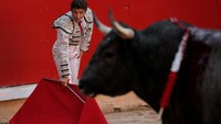 Seorang matador tengah bersiap memasuki arena pertarungan dengan membawa kain berwarna merah untuk menarik perhatian banteng. Jon Nazca/Reuters.