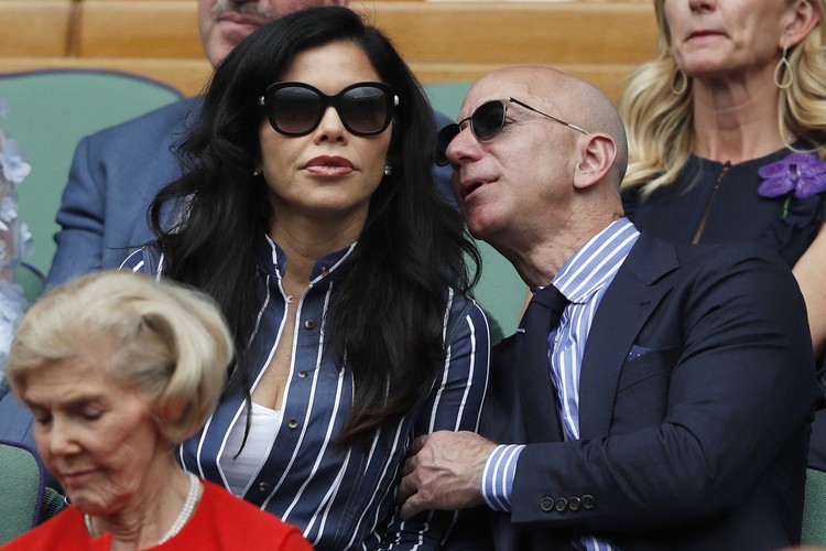 Amazon Founder and CEO Jeff Bezos, right, and Lauren Sanchez, watch Serbias Novak Djokovic play Switzerlands Roger Federer during the mens singles final match of the Wimbledon Tennis Championships in London, Sunday, July 14, 2019. (Adrian Dennis/Pool Photo via AP)