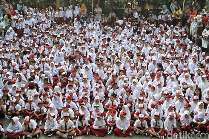 Ratusan siswa SD mengikuti upacara di Hari pertama sekolah di SDN 01 Rawa Badak Utara, Jakarta Utara. Mereka memakai seragam Merah Putih.