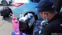 Petugas Suku Dinas Lingkungan Hidup mencatat hasil uji emisi gas buangan kendaraan bermotor roda empat untuk mengukur tingkat kualitas udara yang dikeluarkan kendaraan tersebut.