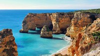 Di Portugal ada lokasi yang bernama Praia da Marinha. Tidak banyak yang berkunjung ke lokasi ini karena jalanan yang tidak terlalu mendukung untuk di lewati, tetapi tempat ini menawarkan lingkungan indah untuk pecinta pantai. Jose Luis Pulido/Getty Images.