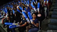 Para penonton meneriakan yel-yel.