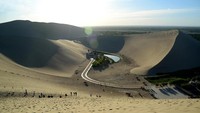 Crescent Lake berada di di balik gundukan pasir besar, seakan berada di lembah. Jika badai gurun datang, maka pasir akan terbang ke gundukan di belakangnya. (iStock)