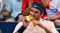 Camilan sehat dan praktis ala Federer adalah pisang. Ekspresi Federer saat makan pisang pun kelihatan semangat ya hihihi. Foto: Business Insider