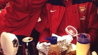 Wah, ternyata Ramsey juga penyuka junk food dan minuman bersoda. Begini gayanya saat makan junk food bareng Wojciech Szczesny. Foto: Emma Lewis