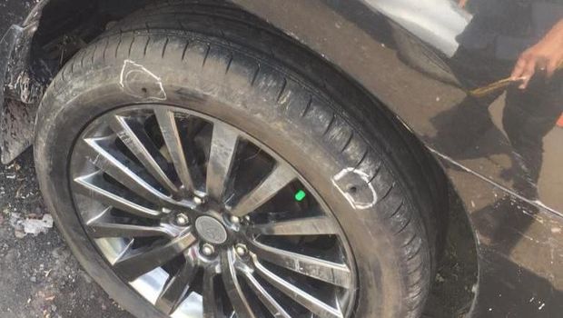 Lubang bekas peluru di dekat ban mobil.