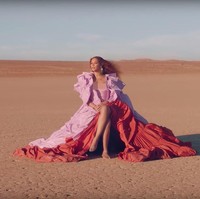 Sebuah adegan menampilkan Beyonce tampil dalam balutan gaun Valentino koleksi Couture Spring 2019 di tengah hamparan padang pasir. Gaun merah-pink itu hadir dengan rok megar yang membuat penyanyi sekaligus pengisi suara Nala itu semakin terasa dramatis. (Foto: YouTube)