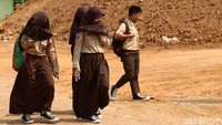 Sejumlah siswa menutupi wajahnya agar terhindar dari debu saat akan berangkat sekolah di SMPN 21 Tangerang, Rabu (17/7/2019).