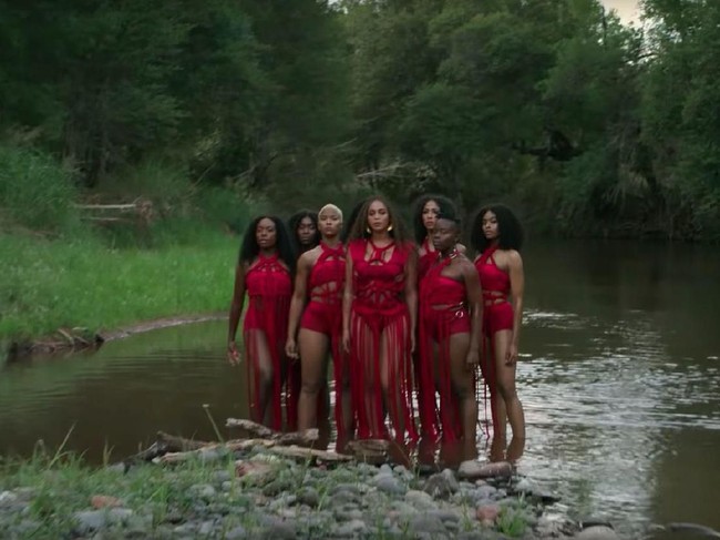 Ia juga memakai bodysuit merah dengan aksen rumbai-rumbai dari Déviant La Vie. (Foto: YouTube)