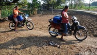 Warga mengangkut jeriken berisi air bersih menggunakan sepeda motor.