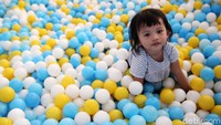 Seorang balita tengah bermain di area bermain anak.