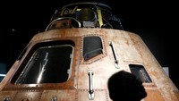 Seorang pengunjung melintas di depan Command Modue yang disebut Columbia yang merupakan kabin untuk tiga astronot yang ikut serta dalam misi Apollo 11 dan satu-satunya bagian pesawat yang kembali ke bumi usai mendarat di bulan 50 tahun silam. Lindsey Wasson/Reuters.