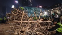 Pantauan detikcom di Bundaran HI Jalan MH Thamrin, Jakarta Pusat, pembongkaran berlangsung hingga pukul 00.05 WIB, Kamis (18/7/2019). Puluhan petugas dilibatkan dalam pembongkaran itu. (Ahmad Bil Wahid/detikcom)