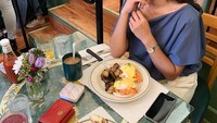 Wanita yang bekerja sebagai pramugari di maskapai Singapura ini rupanya doyan makan enak. Lihat saja tatapan manisnya saat hendak menikmati santapan di Amerika Serikat. Foto: Instagram elwianamonica