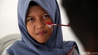 Seorang penonton mengecat wajahnya dengan lambang merah putih.