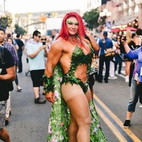 Perempuan bertubuh kekar ini mencoba mencuri perhatian dengan bersolek bak karakter Poison Ivy dari DC Comics. Ia memakai bikini yang seperti terbuat dari daun, disertai cape bertema floral. (Foto: Getty Images)