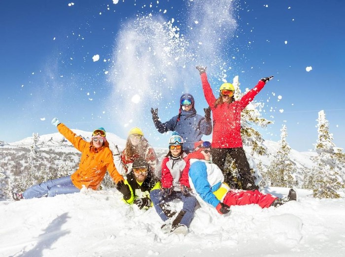 Happy skiers and snowboarders having fun at ski resort. Winter vacations concept