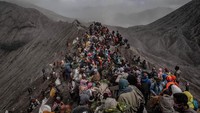 Sebelum dilarung, warga berpakaian khas suku tengger ini membawa sesajen berjalan kaki dengan penerangan lampu obor menuju Pura Luhur Poten.