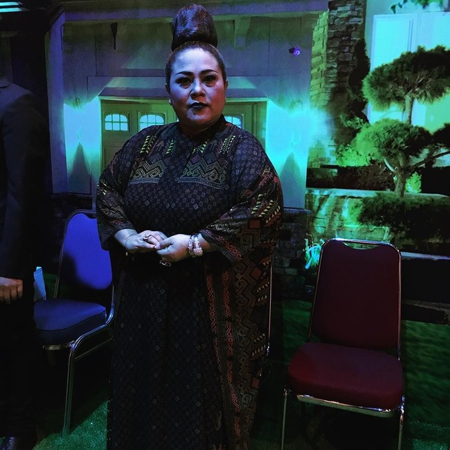 Nuansa gothic dengan dress berwarna gelap serta riasan wajah memakai lipstik hitam. Tetap menghadirkan unsur nyentrik dalam penampilan, rambutnya disanggul tinggi menjulang. Foto: Instagram/@triretnoprayudati_nunung