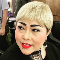Tampil dengan lipstik bold warna merah yang kontras dengan rambut pirangnya. Statement earring dari Dior pun menambah nyentrik gayanya. Foto: Instagram/@triretnoprayudati_nunung