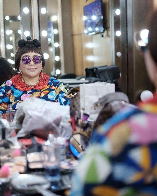 Nunung kerap mengandalkan kacamata hitam untuk menunjang penampilannya. Kali ini ia bergaya dengan baju motif payung, kacamata hitam, dan rambut berponi yang disanggul sebagian. Foto: Instagram/@triretnoprayudati_nunung