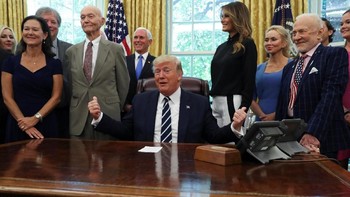 Donald Trump di ruang oval Gedung Putih bersama Buzz Aldrin di sebelah kanan dan Michael Collins di sebelah kiri. Wakil Presiden AS, Mike Pence, dan pejabat NASA juga hadir. Foto: Reuters