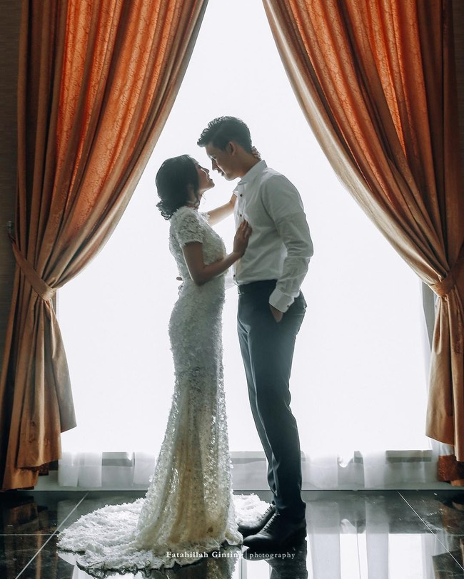 Inspirasi foto prewedding indoor dengan konsep glamour namun simpel juga datang dari pasangan Rinni Wulandari dan Jevin Julian. Rinni tampil cantik bak pengantin dengan gaun yang panjangnya menyapu lantai. Foto: Instagram