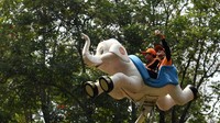 Seorang petugas Penanganan Prasarana dan Sarana Umum (PPSU) melakukan swafoto saat bermain di Dufan, Ancol.