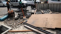 Pekerja tampak membongkar jalan untuk pelebaran trotoar.