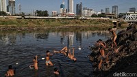 Anak-anak bermain air di Kanal Banjir Barat.