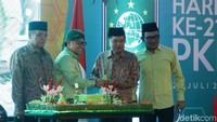 JK menerima potongan tumpeng dari Ketua Umum PKB Muhaimin Iskandar.