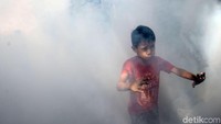 Anak-anak mengikuti saat petugas fogging beraksi.