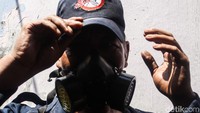 Ia memakai alat keselamatan diri, yaitu masker.