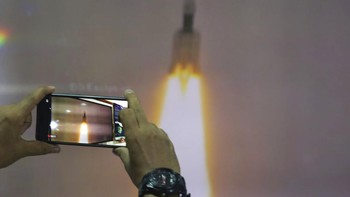 Seorang warga mengabadikan terbangnya misi Chandrayaan 2. Foto: Associated Press