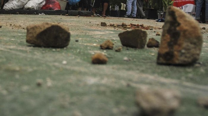 Petugas kebersihan Rutan membersihkan batu dan puing-puing sisa kerusuhan yang berujung pada kaburnya ratusan tahanan di Rutan Sialang Bungkuk Kelas IIB Pekanbaru, Riau, Sabtu (6/5). Akibat kerusuhan pada Jumat (5/5) lalu, dua fasilitas Rutan dan sejumlah mobil rusak serta ratusan tahanan melarikan diri. Hingga saat ini tahanan kabur yang sudah tertangkap sebanyak 212 orang. ANTARA FOTO/Rony Muharrman/aww/17.