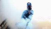 Seorang petugas tengah menyemprotkan asap membasmi jentik nyamuk