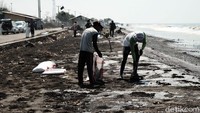 Warga berkumpul di pesisir pantai Kabupaten Karawang untuk membersihkan tumpahan minyak yang mengotori pantai-pantai tersebut.