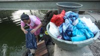 Seorang warga mencuci pakaian di anak Sungai Cisadane, Tangerang.