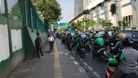  Mereka menunggu para pekerja yang memesan lewat layanan daring, beberapa ada yang baru menurunkan penumpang di stasiun.
