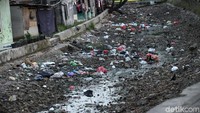 Kini sungai yang mengering itu tampak dikotori oleh sampah.